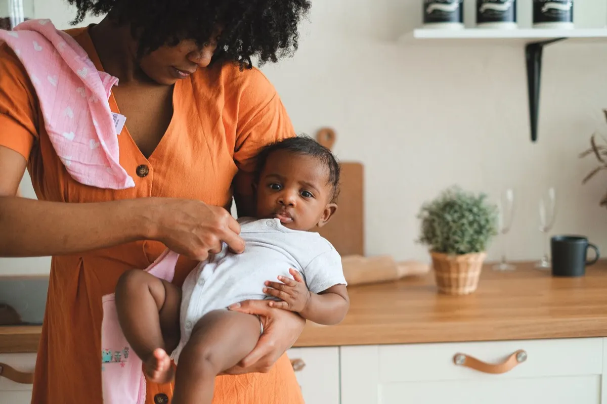 A parent and young child at a kitchen table at home