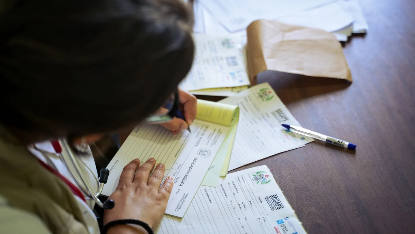 A clinician writing at a desk